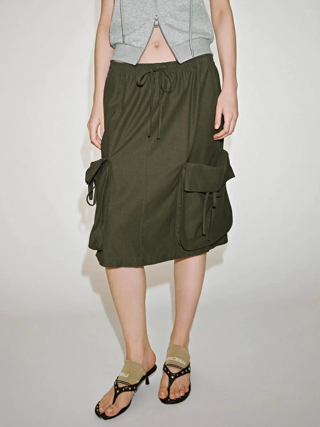18535-olive-cotton-drawstring-cargo-flap-pockets-midi-skirts-1.webp Olive Cotton Drawstring Cargo Flap Pockets Midi Skirts